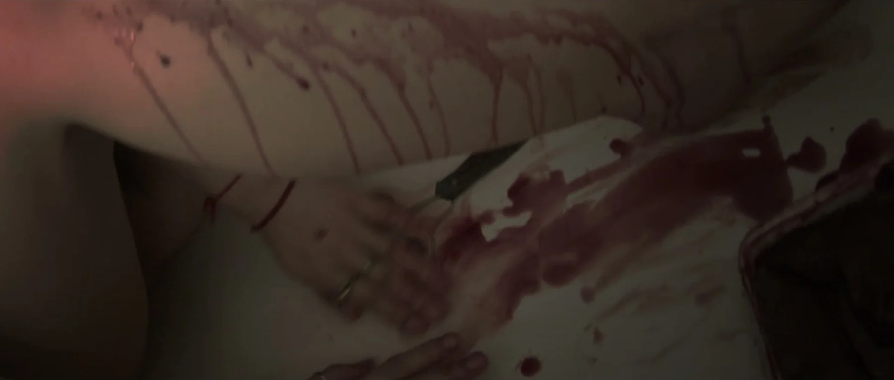 6PM — a close-up of hands and red streaks in the final bathroom scene