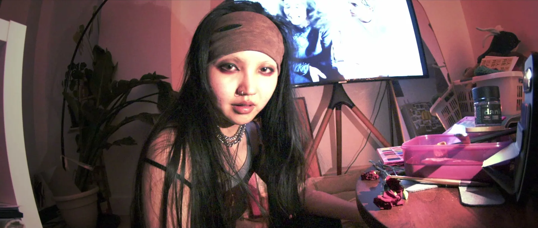 6PM — a close-up in a pink-lit room