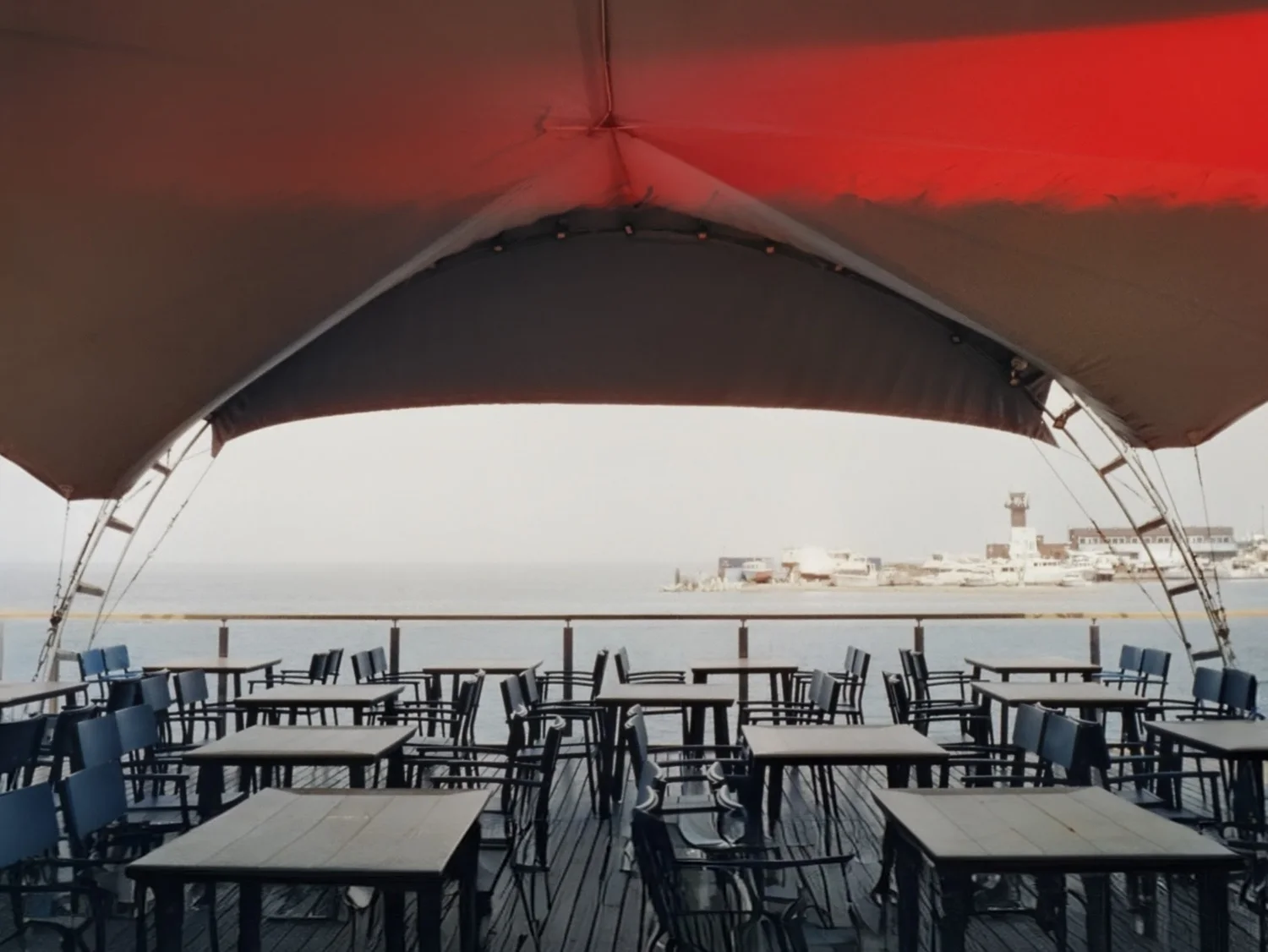 Film photograph of a seaside terrace under a curved canopy